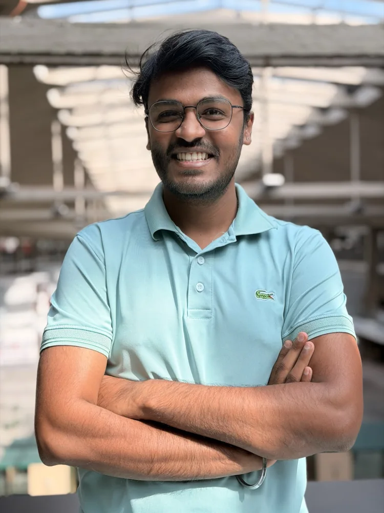 Shivam smiling in a pale green polo shirt
