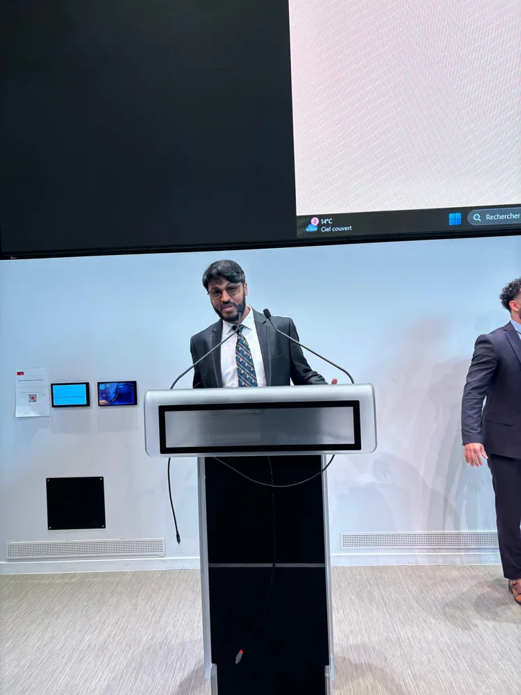 Shivam speaking at a lectern