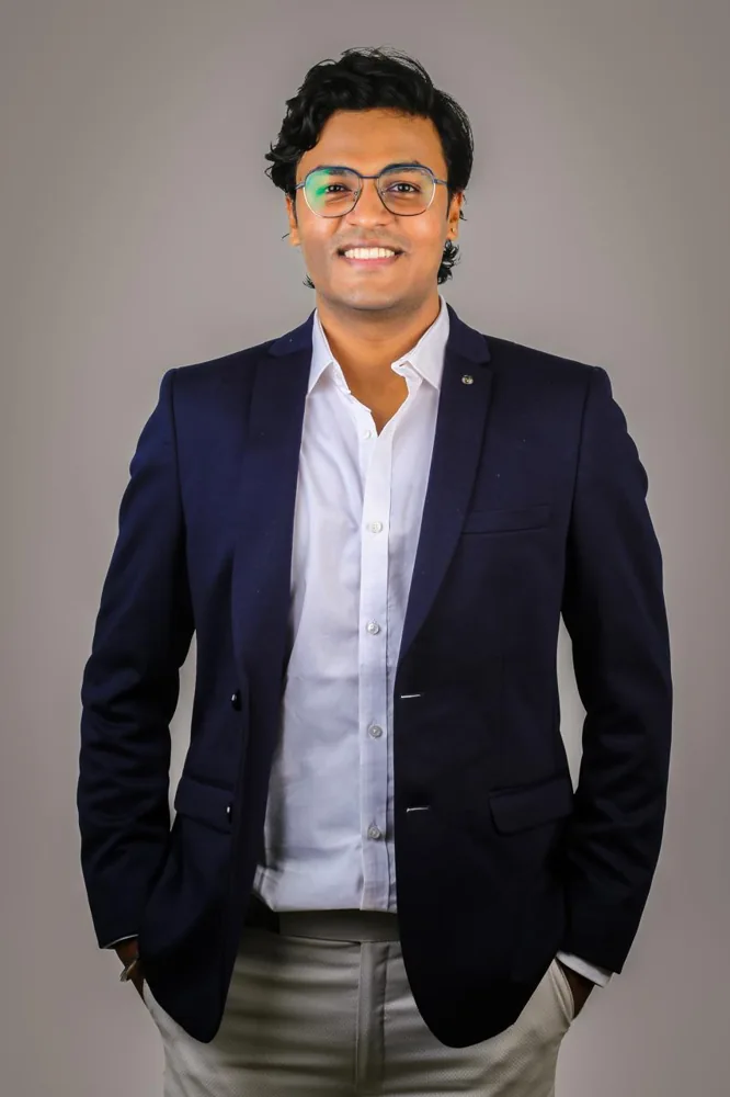 A formal portrait of Shivam in a navy jacket and white shirt